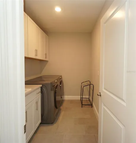 a utility room with sink dryer and washer