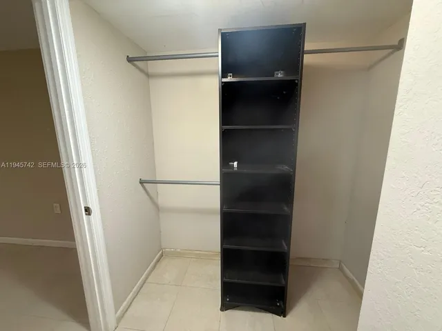 a view of walk in closet with empty racks