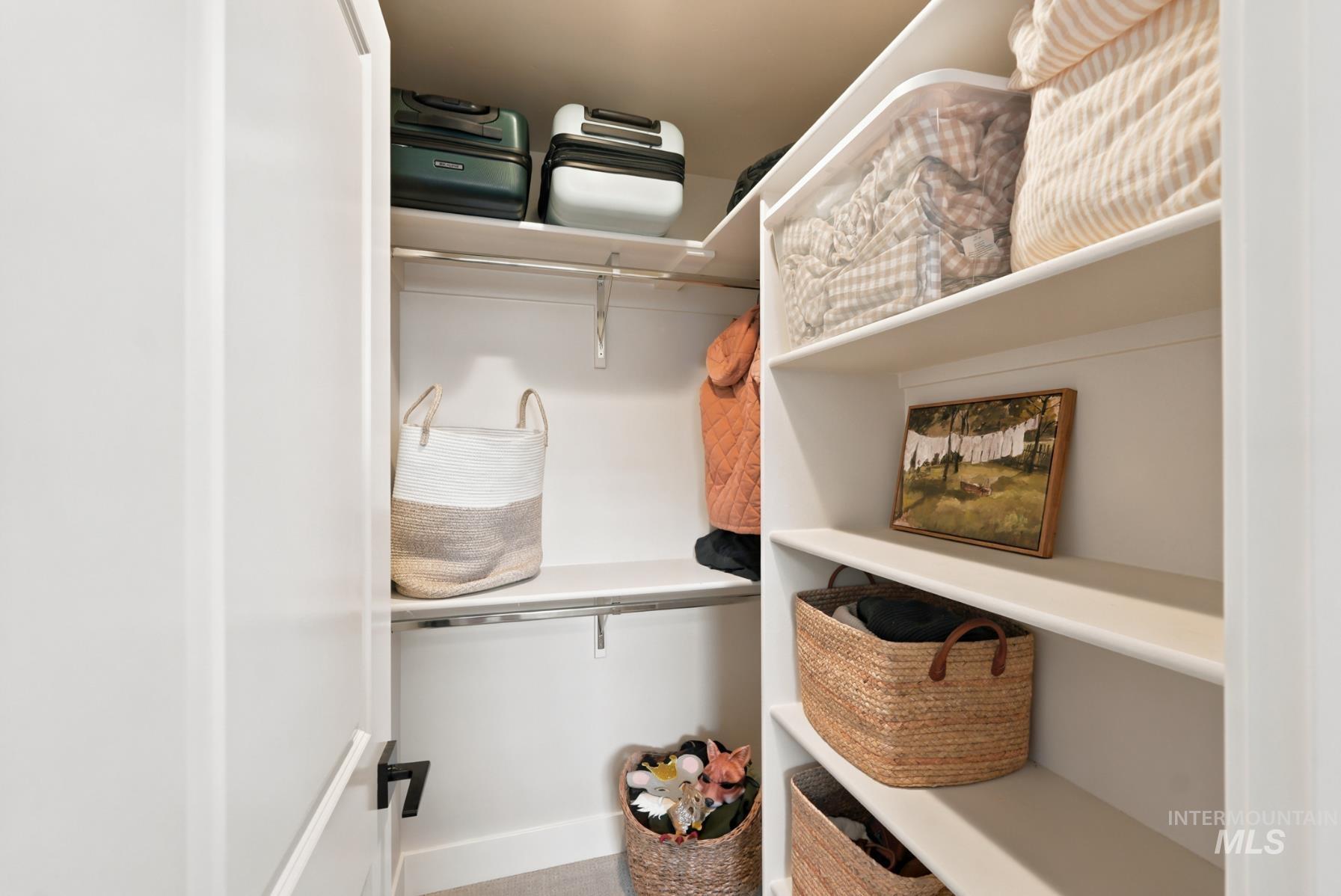 6933 South Zenith Avenue Meridian, ID 83642 - Photo 10 of 34 Walk-in closet featuring white built-in shelving, multiple hanging rods, and light-colored walls