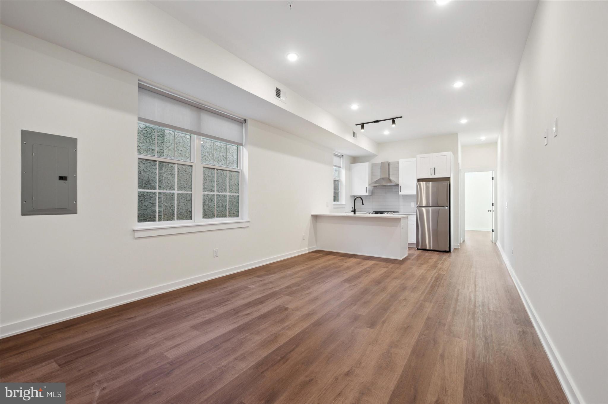 2513 North Howard Street, Unit 303 Philadelphia, PA 19133 - Photo 3 of 24 a view of an empty room with a window and wooden floor