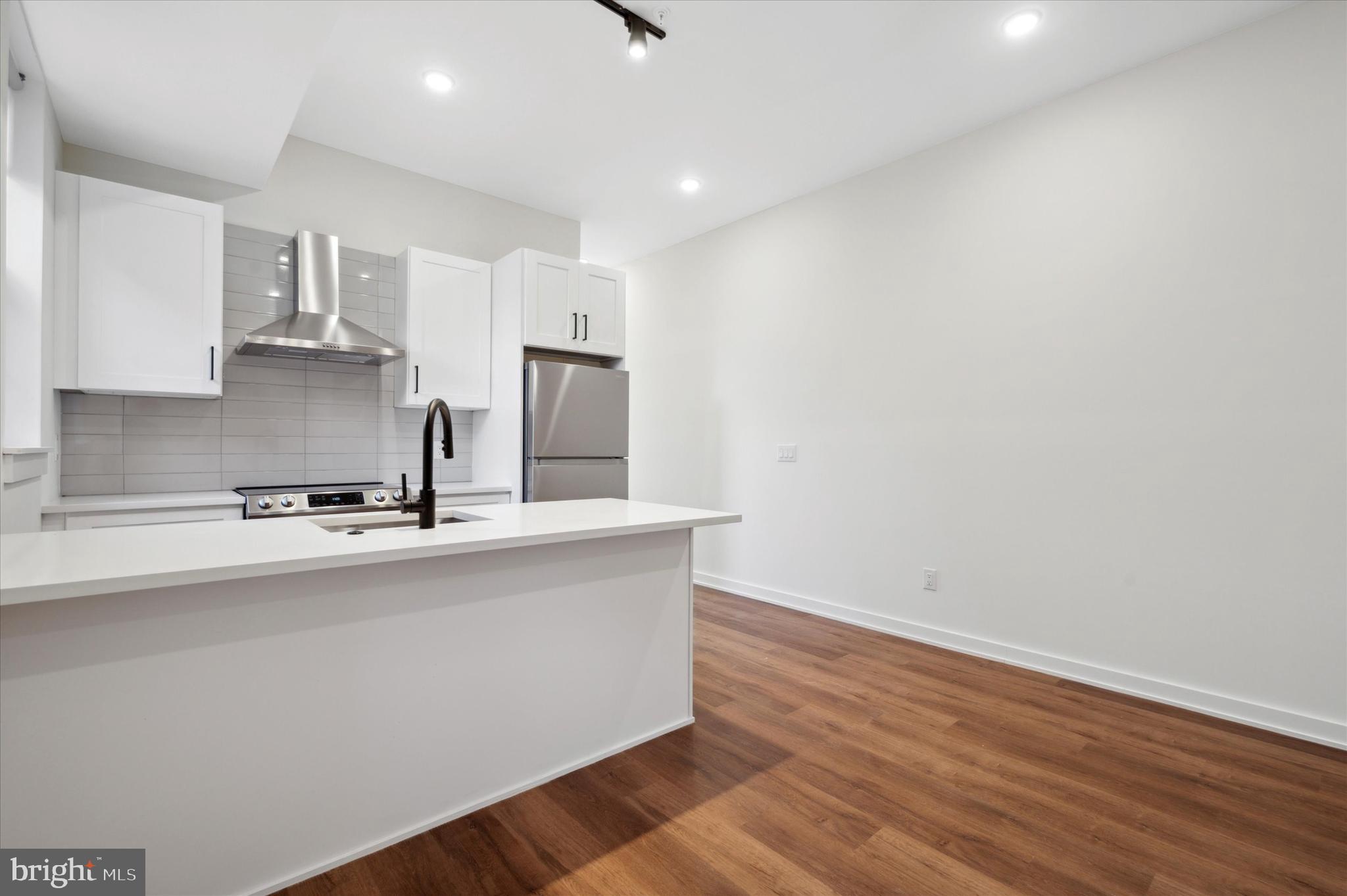 2513 North Howard Street, Unit 303 Philadelphia, PA 19133 - Photo 6 of 24 a kitchen with stainless steel appliances a sink a stove a refrigerator and cabinets