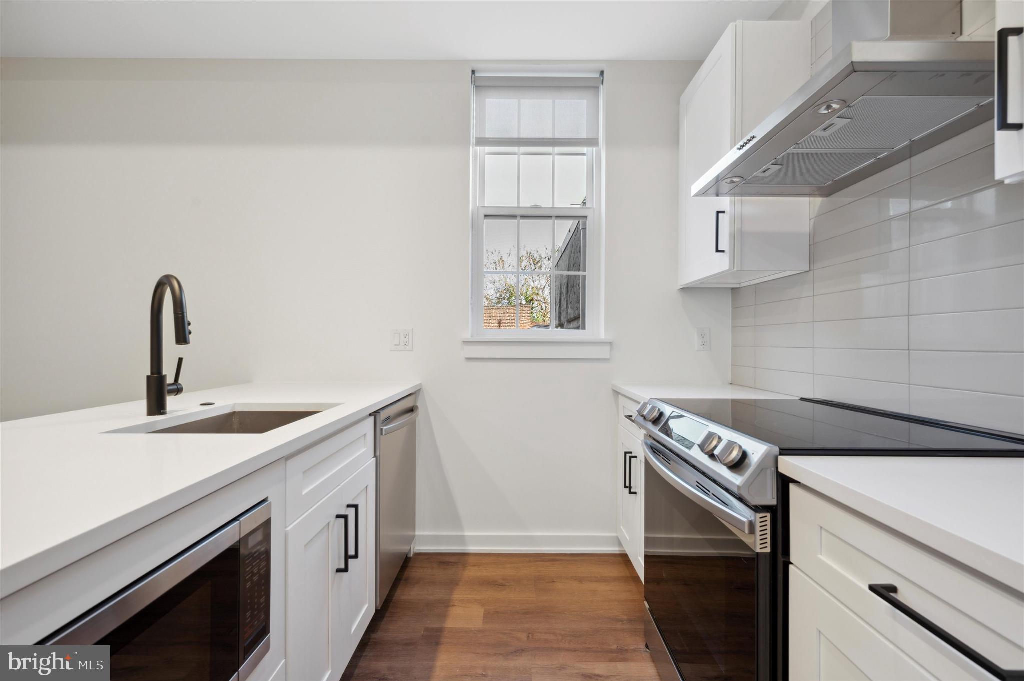 2513 North Howard Street, Unit 303 Philadelphia, PA 19133 - Photo 10 of 24 a kitchen with a sink stove and cabinets