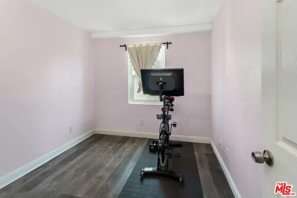 a room with gym equipment and wooden floor