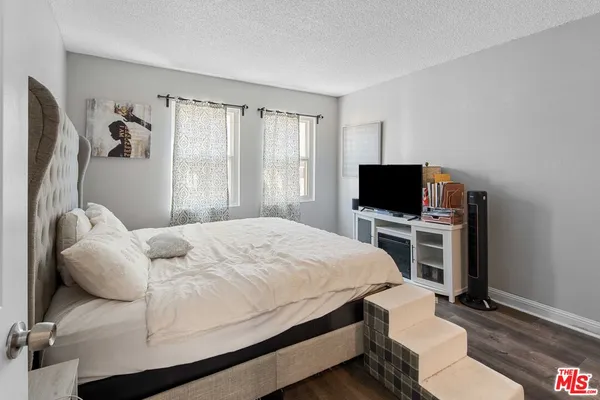 a bedroom with a bed and a flat screen tv