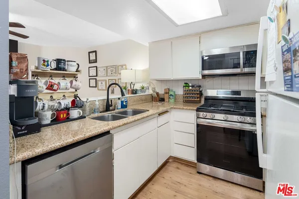 a kitchen with stainless steel appliances granite countertop a sink stove and microwave