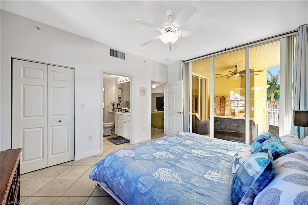 410 Bayfront Place, Unit 2409 Naples, FL 34102 - Photo 11 of 23 a bedroom with a large bed and a chandelier