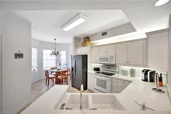 a kitchen with granite countertop a sink appliances and cabinets