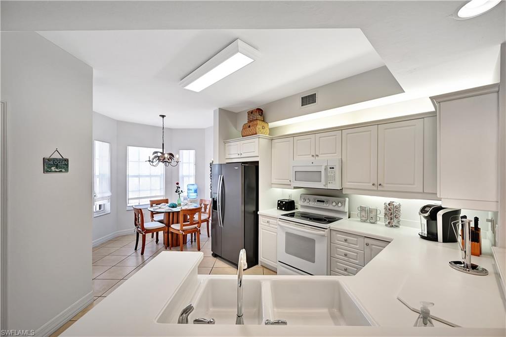 410 Bayfront Place, Unit 2409 Naples, FL 34102 - Photo 7 of 23 a kitchen with granite countertop a sink appliances and cabinets
