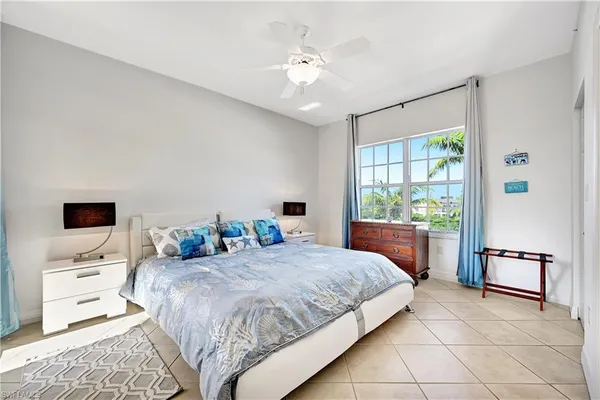 a bedroom with a bed and a flat tv screen on the dresser