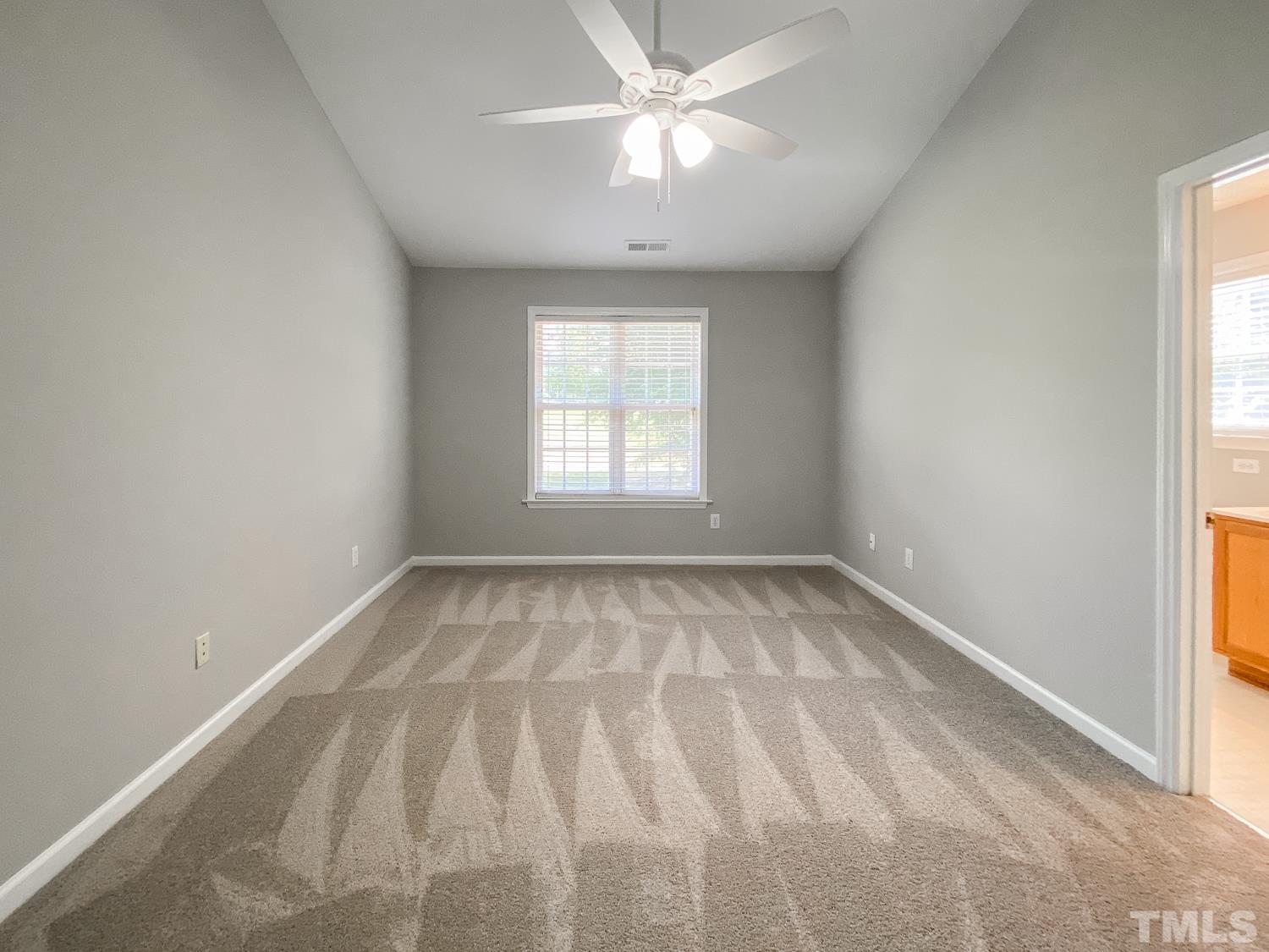 5242 Eagle Trace Drive Raleigh, NC 27604 - Photo 16 of 24 an empty room with a window and a fan