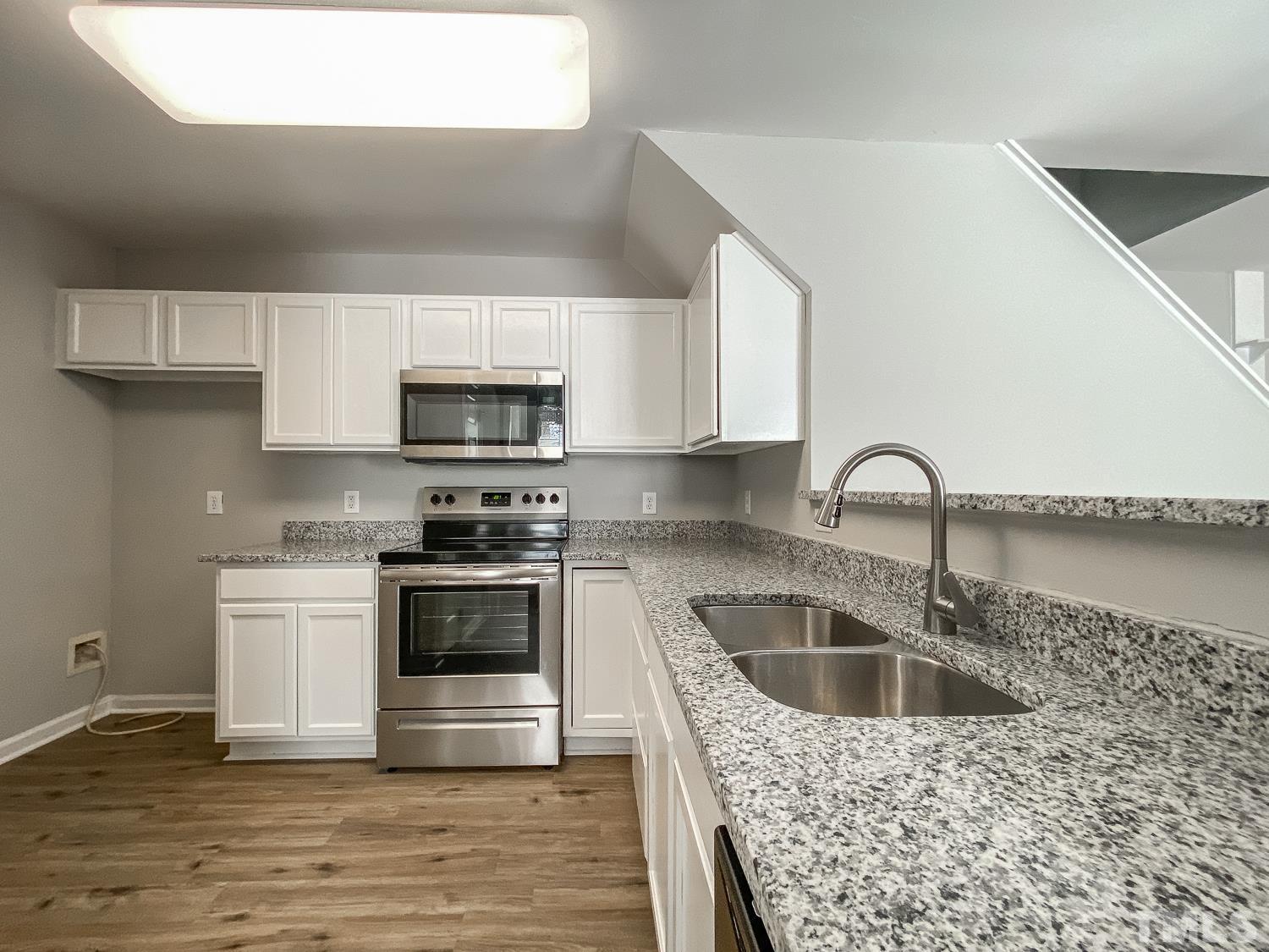 5242 Eagle Trace Drive Raleigh, NC 27604 - Photo 3 of 24 a kitchen with stainless steel appliances a stove a sink a microwave and cabinets
