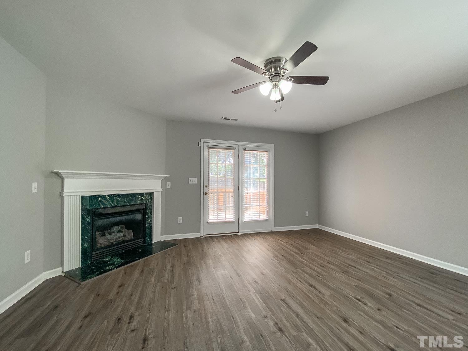 5242 Eagle Trace Drive Raleigh, NC 27604 - Photo 8 of 24 a view of an empty room with wooden floor fireplace and a window