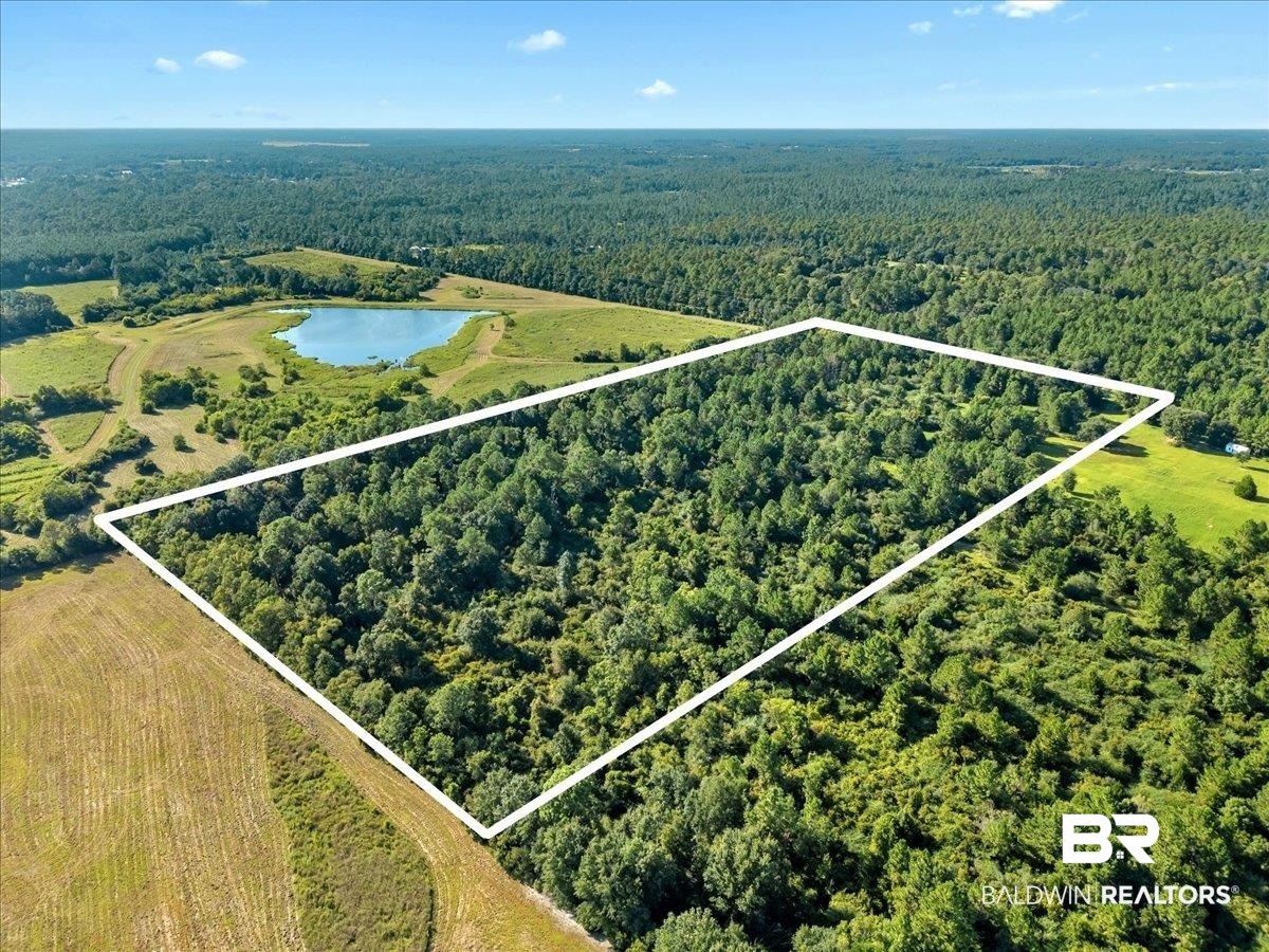 Aerial view of property and surrounding area featuring a nearby body of water and property parcel outlined