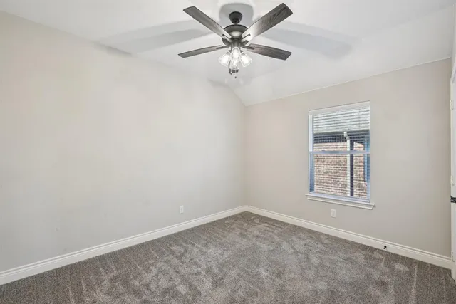an empty room with windows and ceiling fan