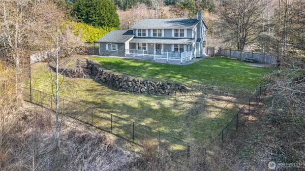 a view of a house with a yard and large trees