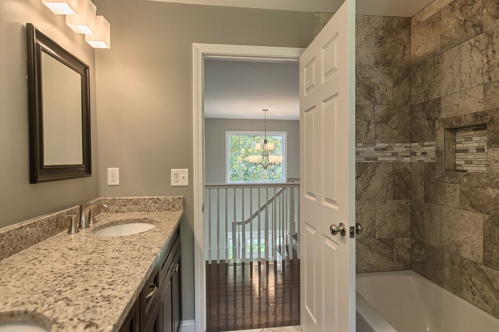 5 Davis Road Chelmsford, MA 01824 - Photo 25 of 27 a bathroom with a granite countertop sink a mirror and a bathtub