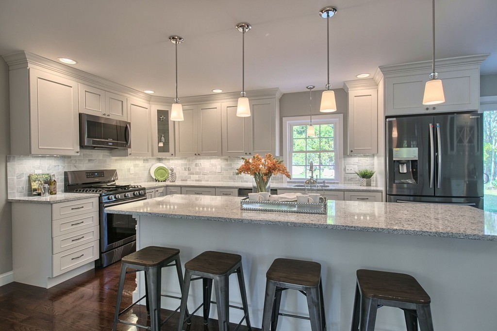 5 Davis Road Chelmsford, MA 01824 - Photo 4 of 27 a kitchen with stainless steel appliances a table chairs refrigerator and microwave