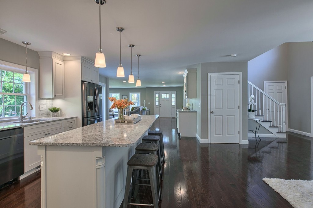 5 Davis Road Chelmsford, MA 01824 - Photo 6 of 27 a kitchen with stainless steel appliances granite countertop a stove a sink a refrigerator and a dining table with wooden floor