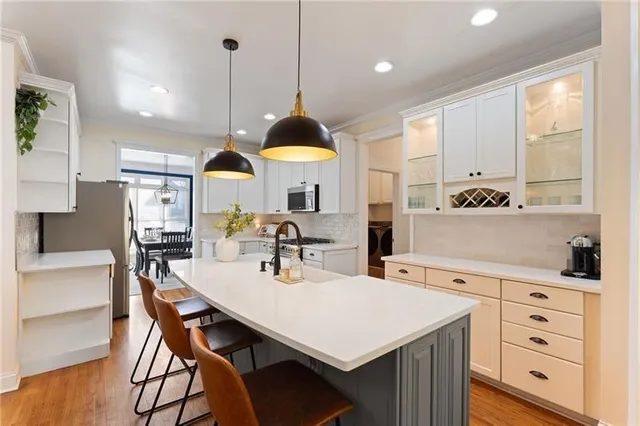 a kitchen with stainless steel appliances a stove a sink a table and chairs