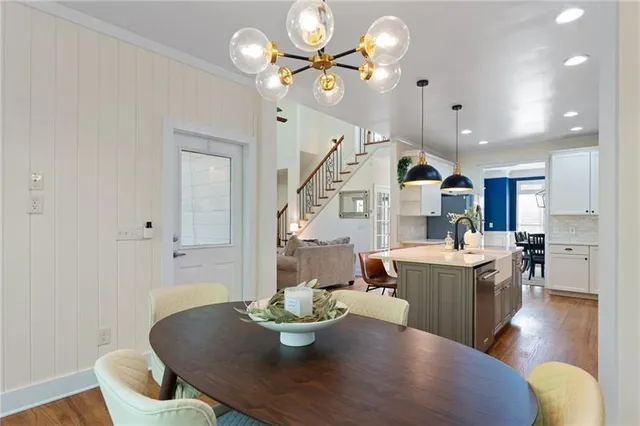 a living room with furniture kitchen view and a chandelier