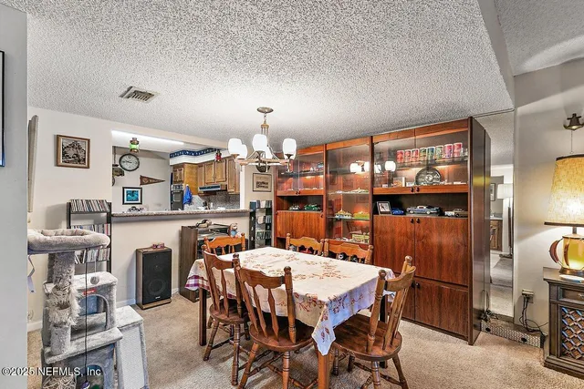 a dining room with a table chairs and a kitchen view