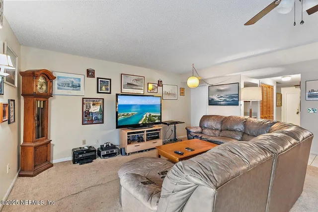 a living room with furniture a flat screen tv and a wall painting