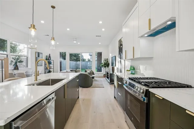 a kitchen with counter top space a sink a stove a refrigerator and blue cabinets