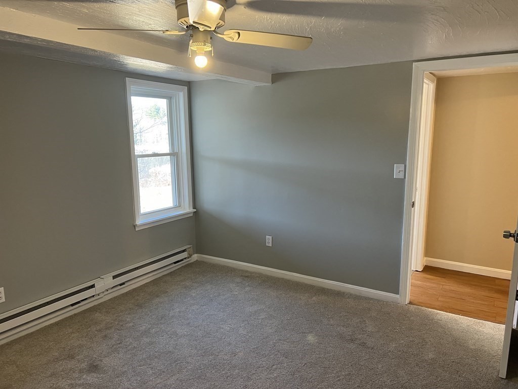 1124 Bemis Road, Unit B Warren, MA 01585 - Photo 32 of 42 an empty room with windows and fan