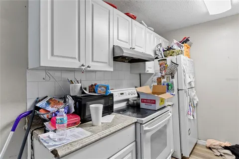 a kitchen with a refrigerator and a stove top oven