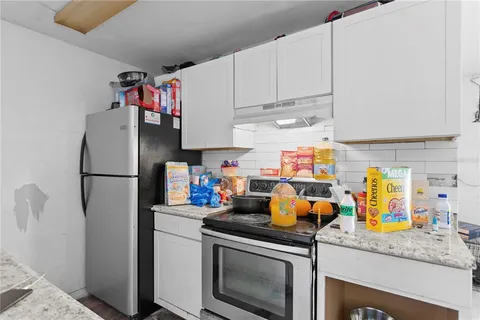 a kitchen with stainless steel appliances granite countertop a refrigerator and a stove