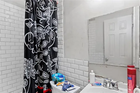 a bathroom with a toilet and a shower curtain