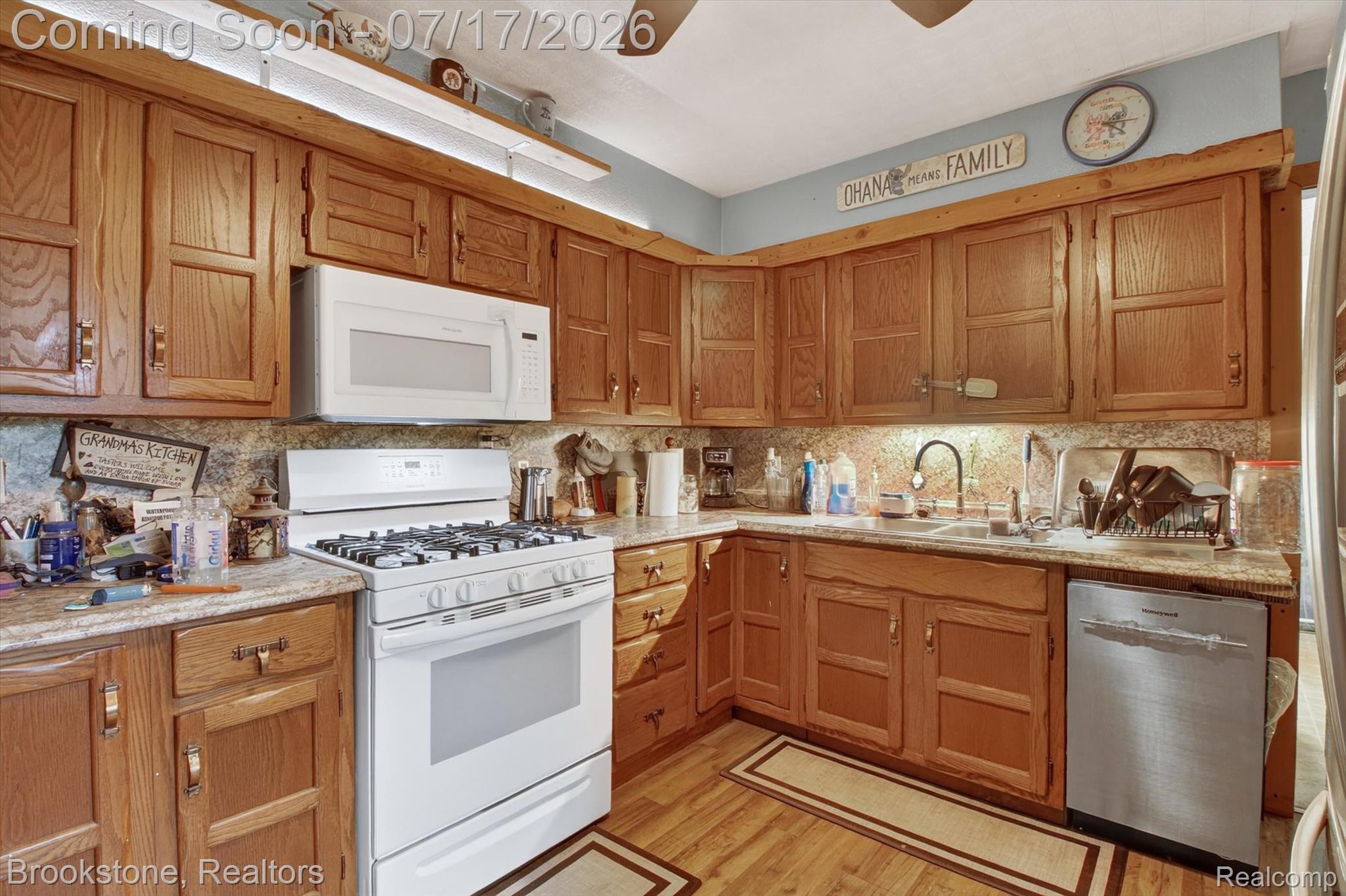 22709 Pleasant Valley Road Hillman, MI 49746 - Photo 15 of 42 Kitchen with wood cabinetry, light countertops, and a tile backsplash