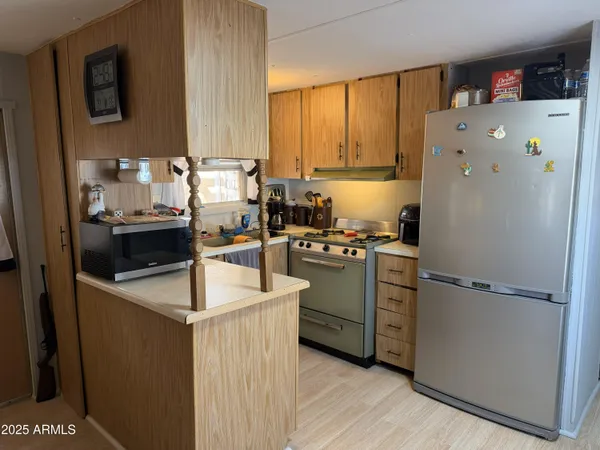 a kitchen with a refrigerator sink and cabinets