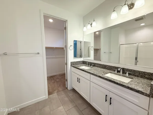 a spacious bathroom with a granite countertop sink and a mirror