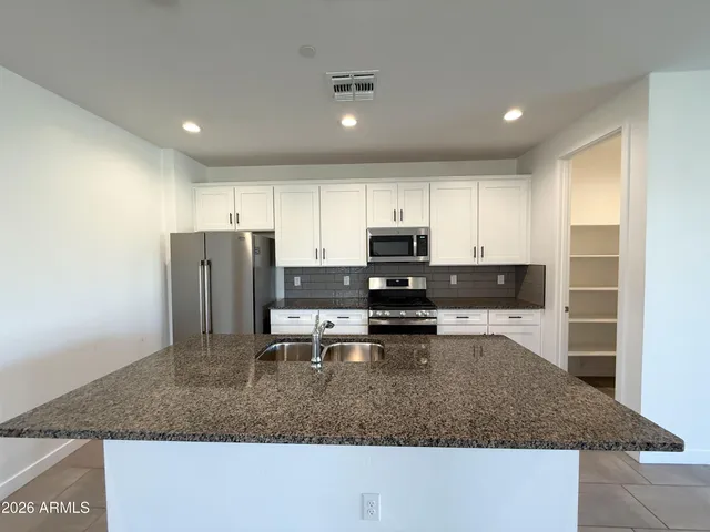 a kitchen with stainless steel appliances granite countertop a sink refrigerator and microwave