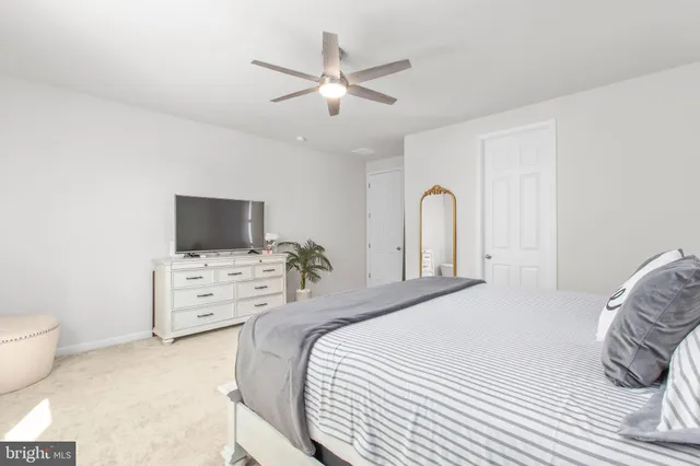 a bedroom with a bed flat screen tv and a window