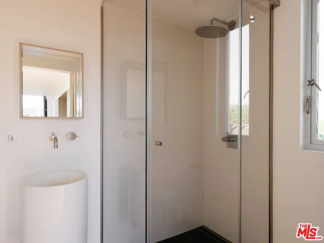 a bedroom with a bed and a night stand next to a window