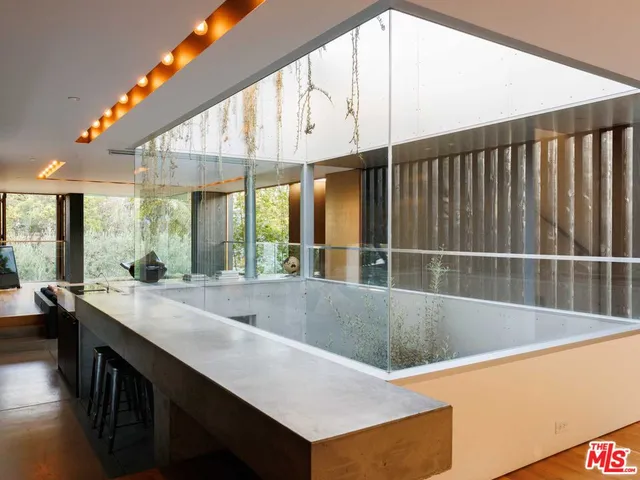 a large kitchen with kitchen island a large window a sink and counter space
