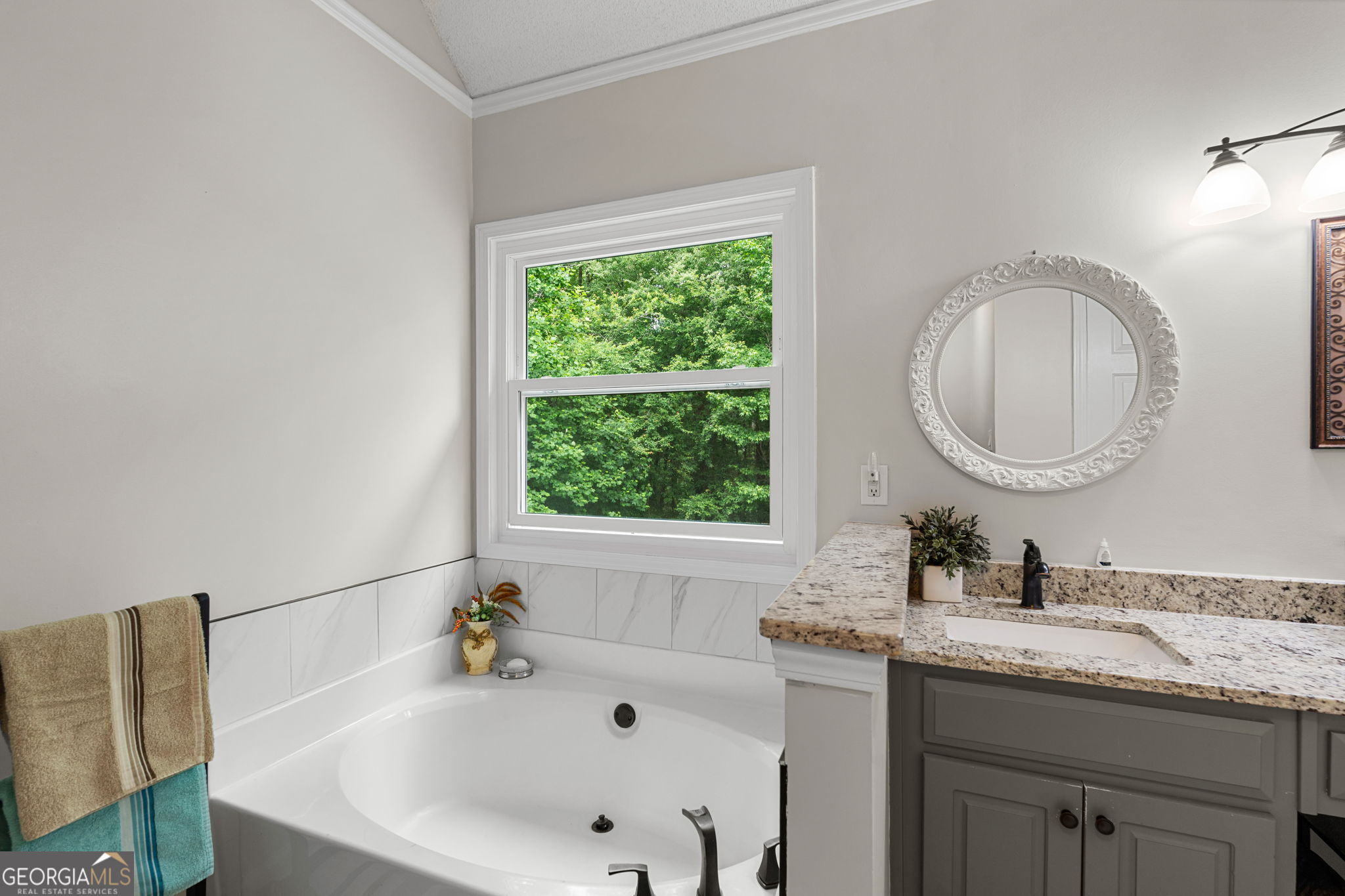 375 Gaelic Way Tyrone, GA 30290 - Photo 34 of 54 a bathroom with a granite countertop sink a mirror and a bathtub