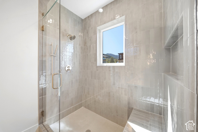4092 Discovery Way Park City, UT 84098 - Photo 34 of 66 Glass-enclosed shower with a rainfall showerhead, handheld shower, integrated tiled bench, and recessed shelving