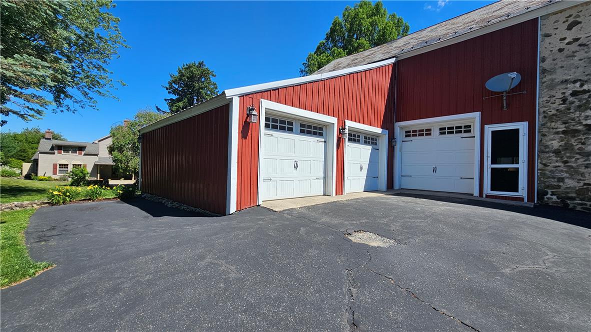 585 Buttermilk Road Hellertown, PA 18055 - Photo 67 of 82 Three attached garage bays offer ample parking, adjacent to a charming stone and siding residence.