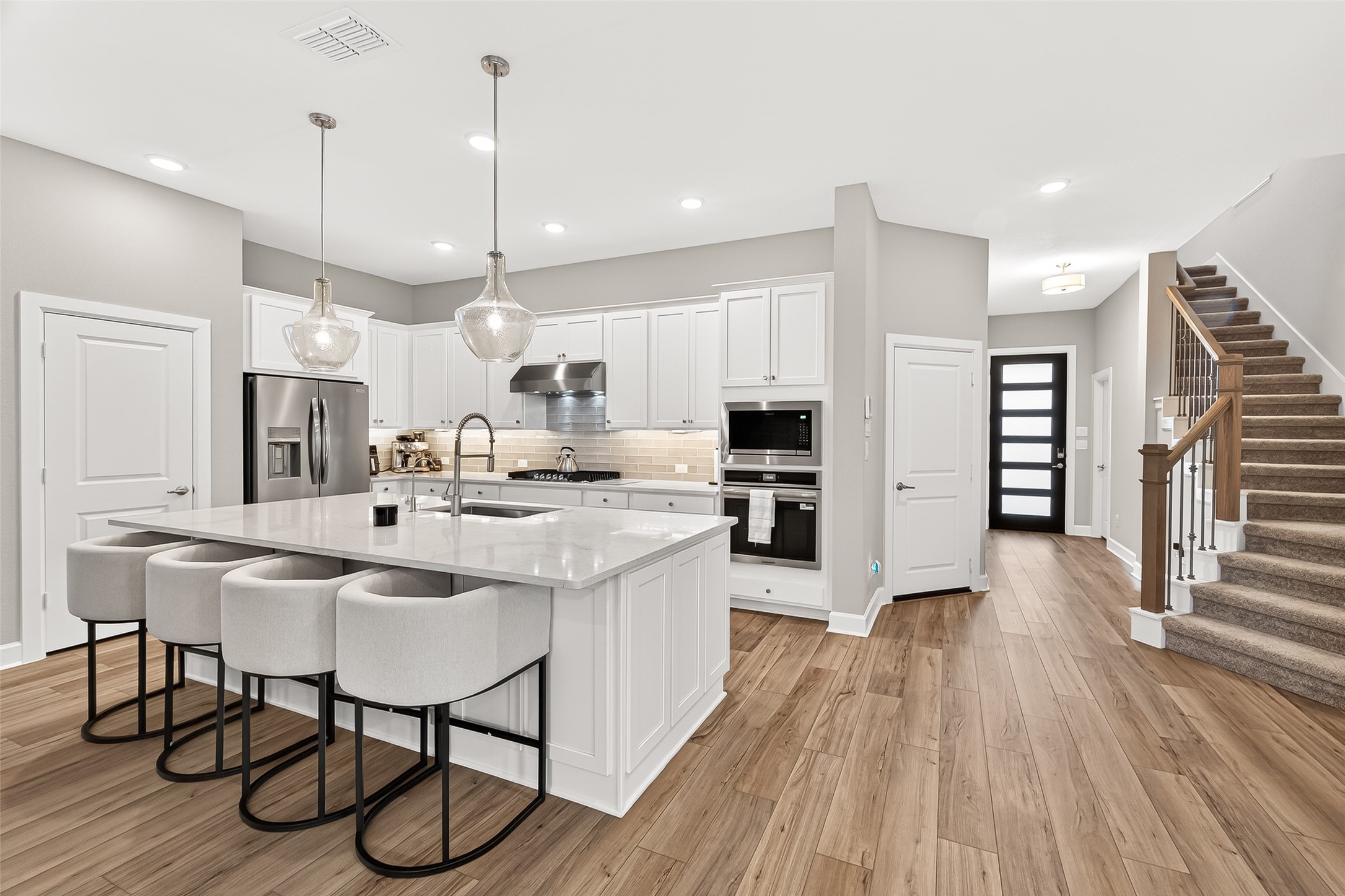 11226 Common Hackberry Street Cypress, TX 77433 - Photo 4 of 17 a kitchen with stainless steel appliances kitchen island granite countertop a table chairs refrigerator and microwave