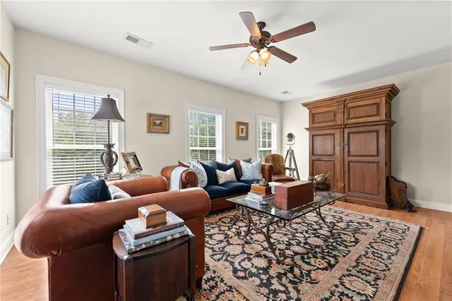 a living room with furniture ceiling fan and a window