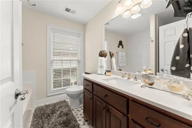 a bathroom with a granite countertop sink a large mirror and a shower