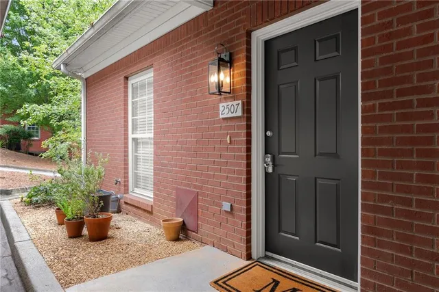 a view of a door of the house and potted plants