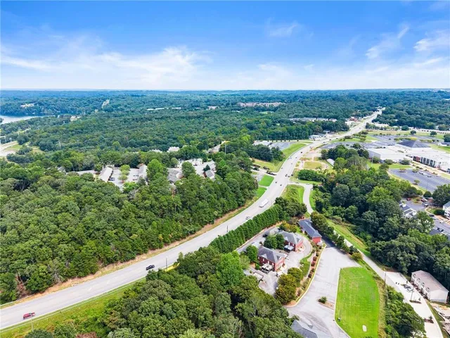 an aerial view of residential houses with outdoor space and trees