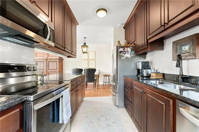a kitchen with stainless steel appliances granite countertop a sink stove and cabinets