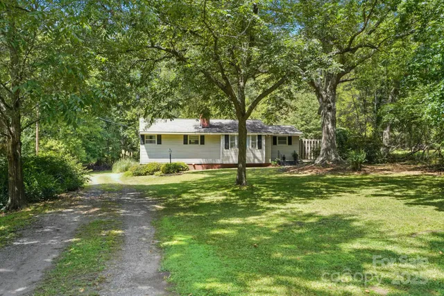 a backyard of a house with table and chairs and potted plants