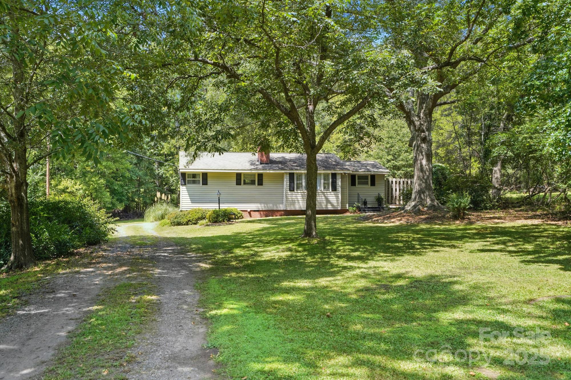 a backyard of a house with table and chairs and potted plants