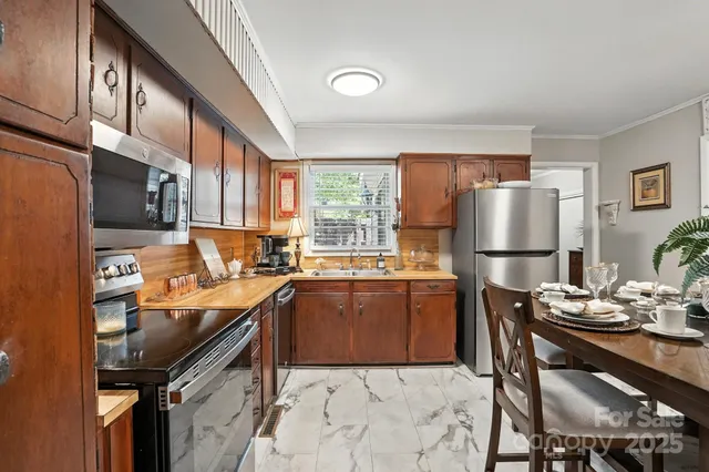 a kitchen with granite countertop a refrigerator stove and sink